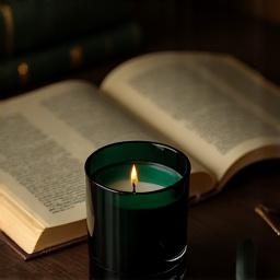 Timothy C Buckley Library candle next to an open, aged book