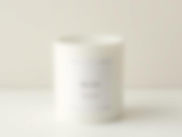Matte white vessel with a clean burning candle titled 'Still - White Tea & Ginger'